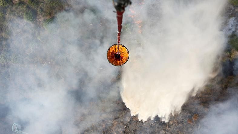 A helicopter from the Disaster Management Agency (BPBD) drops water on a fire in a field in Ogan Komering Ilir regency, South Sumatra, Indonesia in this 19 July 2018 photo. Photo: Reuters