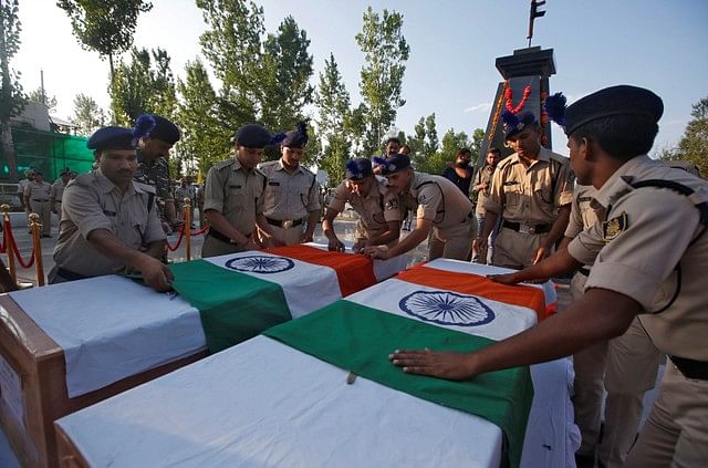 Indian policemen place national flags on the coffins containing the bodies of their two colleagues, who according to police were killed in a militant attack in South Kashmir`s Achabal, during a wreath laying ceremony in Humhama. Photo : Reuters