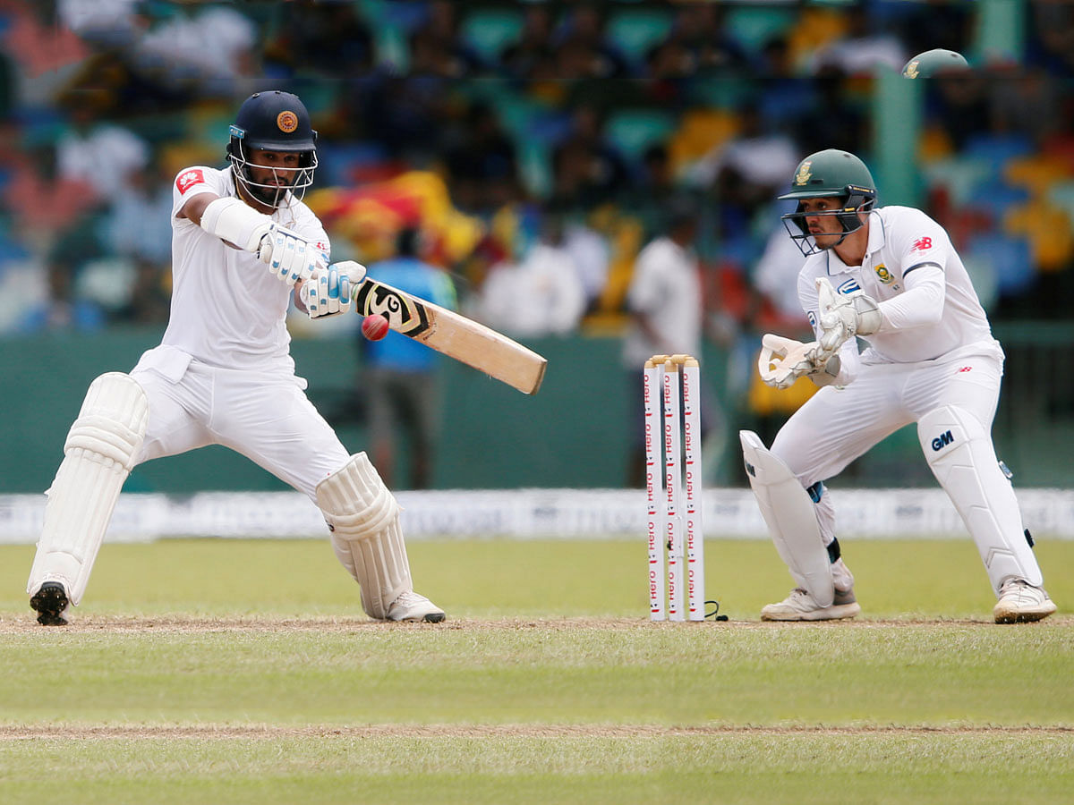 Sri Lanka batsman Dimuth Karunaratne (L) plays a shot next to South Africa wicketkeeper Quinton de Kock in the Second Test Match at Colombo, Sri Lanka on 20 July 2018. Photo: Reuters
