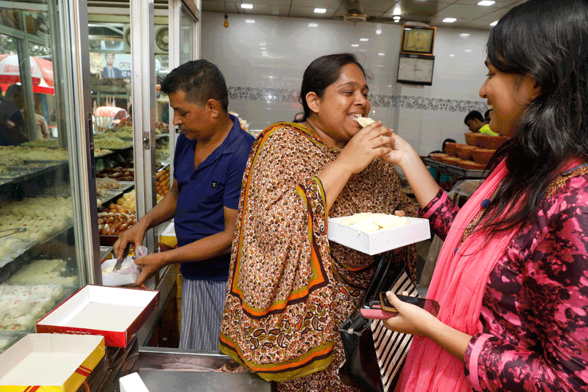 A girl offers sweets to her mother after the result in Lalbagh area of Dhaka. Photo: Dipu Malakar