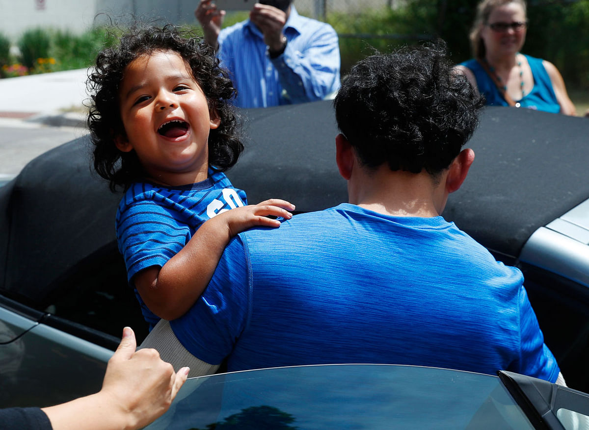 In this 10 July 2018, file photo, Ever Reyes Mejia, of Honduras, carries his son to a vehicle after being reunited and released by United States Immigration and Customs Enforcement in Grand Rapids, Mich. Photo: AP