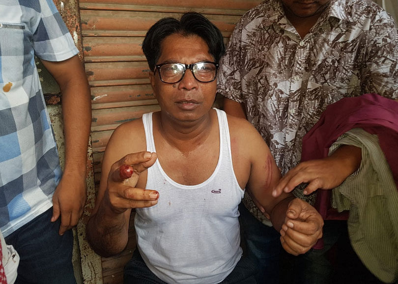 An officer of state-owned Sonali Bank was roughed up by two police men in Tongi on Sunday morning. Photo: Prothom Alo