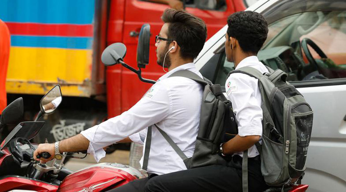 A student wears headphones while riding his motorbike. Neither he nor the passenger has any helmet. The photo was taken from Mayor Mohammad Hanif Flyover, Dhaka on 22 July by Dipu Malakar.
