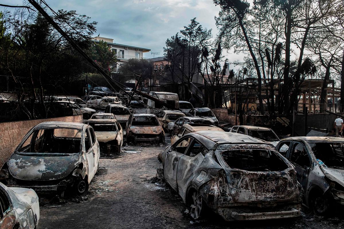 This photo taken on July 24, 2018 show cars burnt following a wildfire at the village of Mati, near Athens, on 24 July 2018. AFP