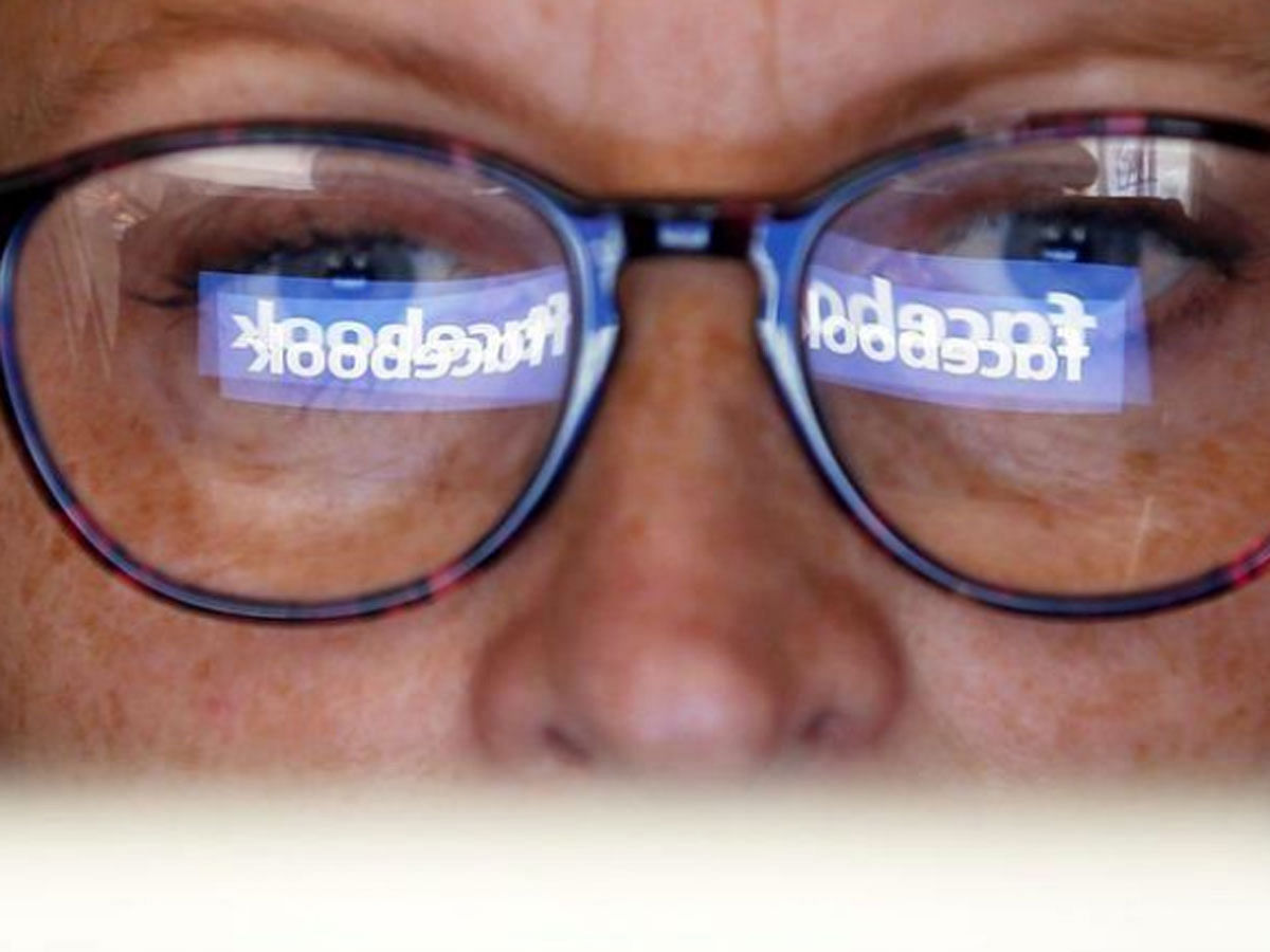 The Facebook logo is reflected on a woman`s glasses in this photo illustration taken on 3 June 2018. -- Reuters