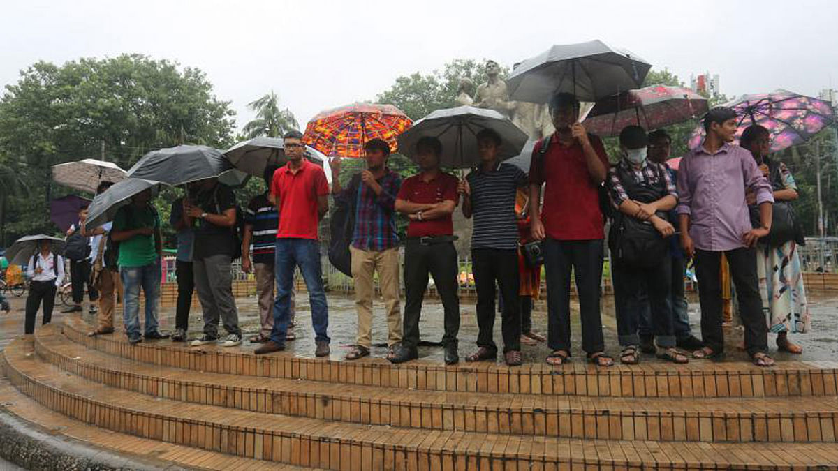Students held umbrellas while forming a human chain at the Raju anti-terrorism sculpture in Dhaka University on 25 July. Photo: Hasan Raja