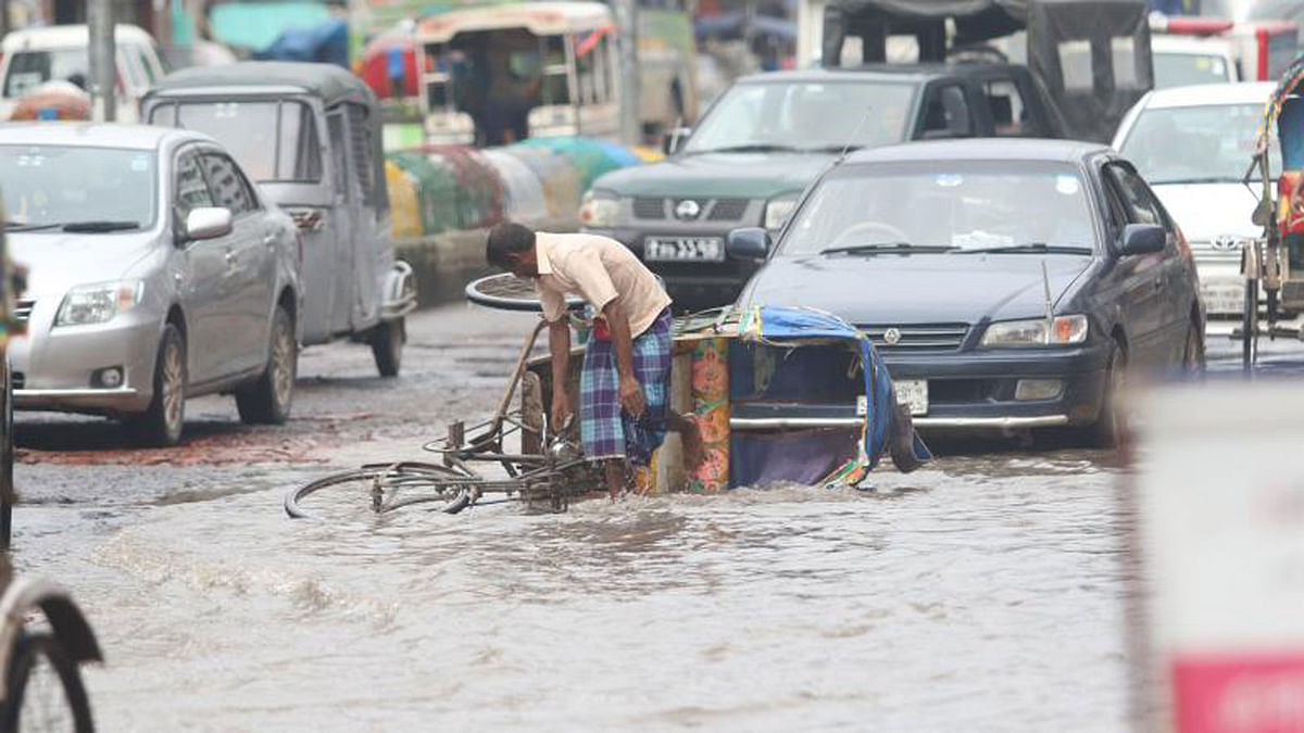 A rickshaw was turned over on the Kalshi Road of Mirpur, Dhaka on 25 July. There are potholes in the road. The waterlogging caused by the torrential monsoon rains has added to the distress. Photo:  Abdus Salam