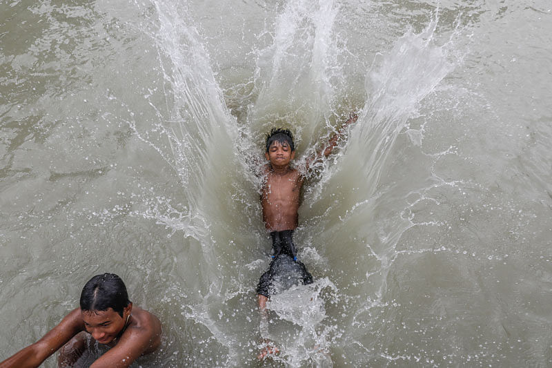 Two boys jump into river to get relief from scorching temperatures in Farshganj Ghat area, Dhaka on 20 July. Photo: Dipu Malakar