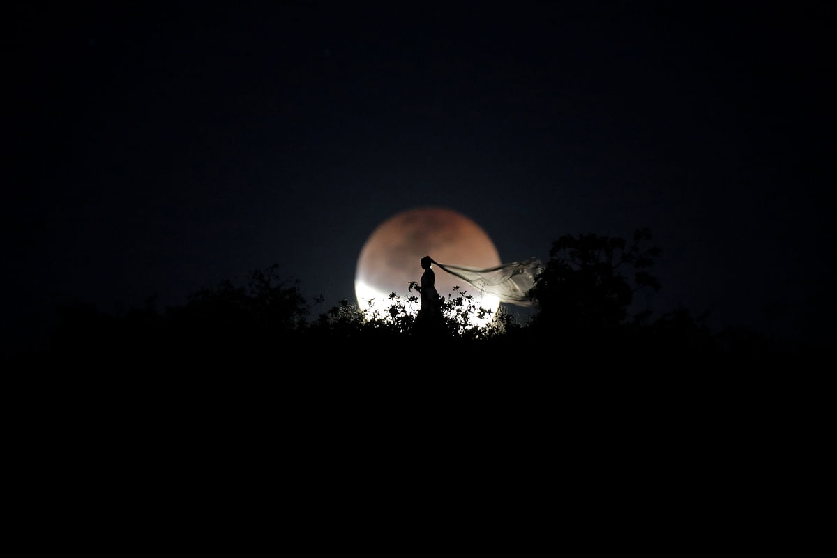A bride poses for photo during a total lunar eclipse from in Brasilia, Brazil, on 27 July 2018. Photo: Reuters