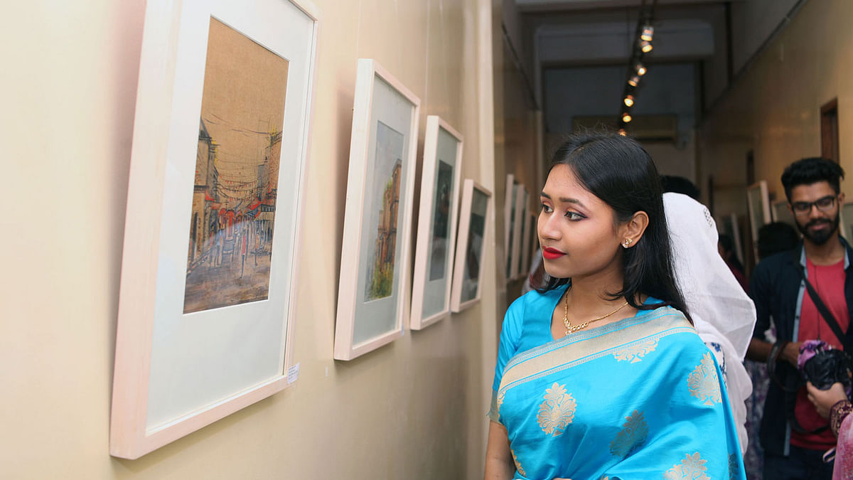 A visitor looks at paintings of a 15-day group art show, ‘Prothom Parbo’ (The First Chapter), by ‘Outdoor Artist Group’ at Galerie Zoom of Alliance Française de Dhaka (AFD) on Friday. Photo: Prothom Alo
