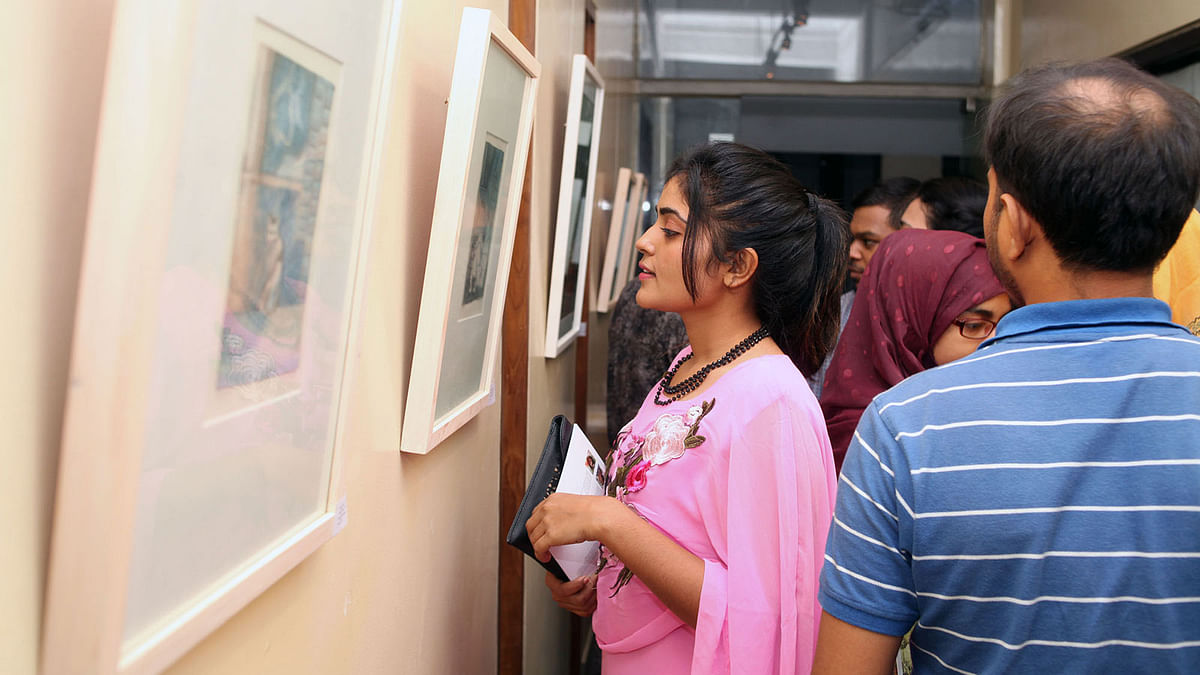 A visitor looks at paintings of a 15-day group art show, ‘Prothom Parbo’ (The First Chapter), by ‘Outdoor Artist Group’ at Galerie Zoom of Alliance Française de Dhaka (AFD) on Friday. Photo: Prothom Alo