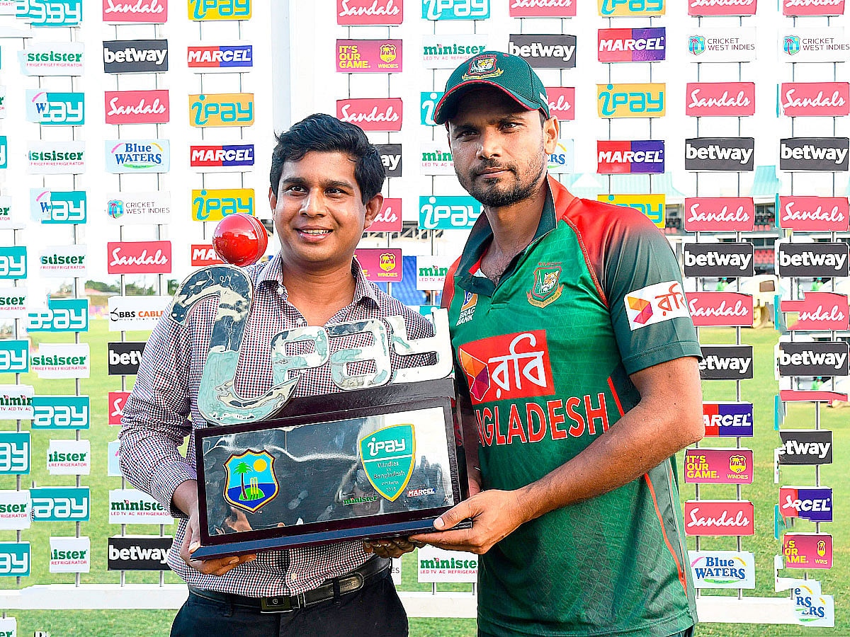 Mashrafe Mortaza (R) of Bangladesh receives the winners trophy from Golam Murtoza Gazi (L) at the end of the 3rd and final ODI match between West Indies and Bangladesh at Warner Park, Basseterre, St. Kitts, on 28 July 2018. Photo: AFP