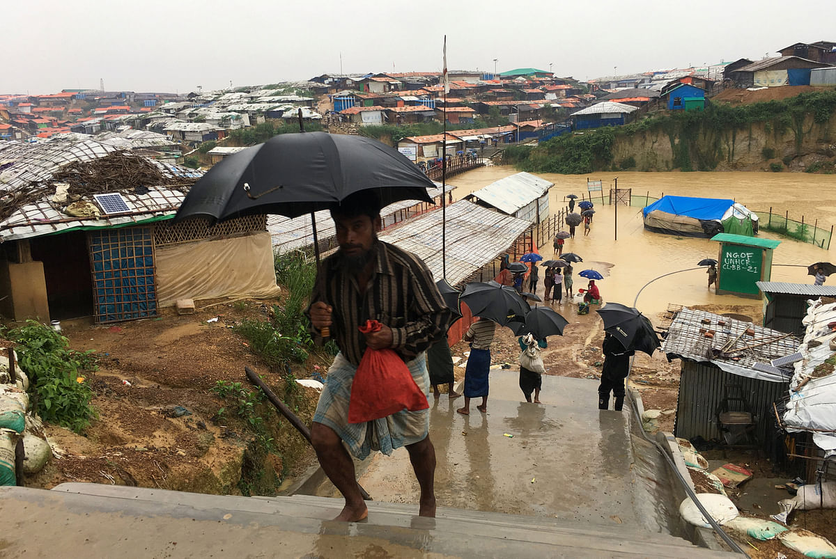 Rohingya refugees walks along the refugee camp during rain in Cox’s Bazar, Bangladesh, on 25 July 2018. Photo: Reuters