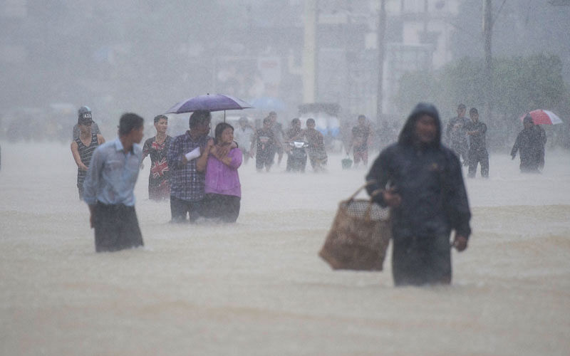 Residents walk in floodwaters in the Bago region, some 68 km away from Yangon, on 29 July, 2018. Photo: AFP