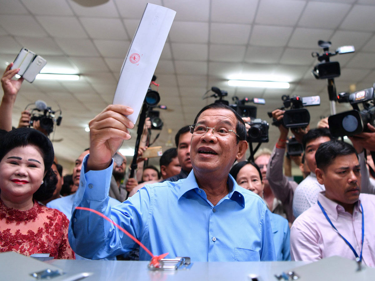 Cambodia`s Prime Minister Hun Sen (C) prepares to cast his vote during the general election as his wife Bun Rany (L) looks on in Phnom Penh on 29 July, 2018.     Cambodia went to the polls early on July 29 in an election set to be easily won by strongman premier Hun Sen after the only credible opposition was dissolved last year, effectively turning the country into a one-party state.     / AFP