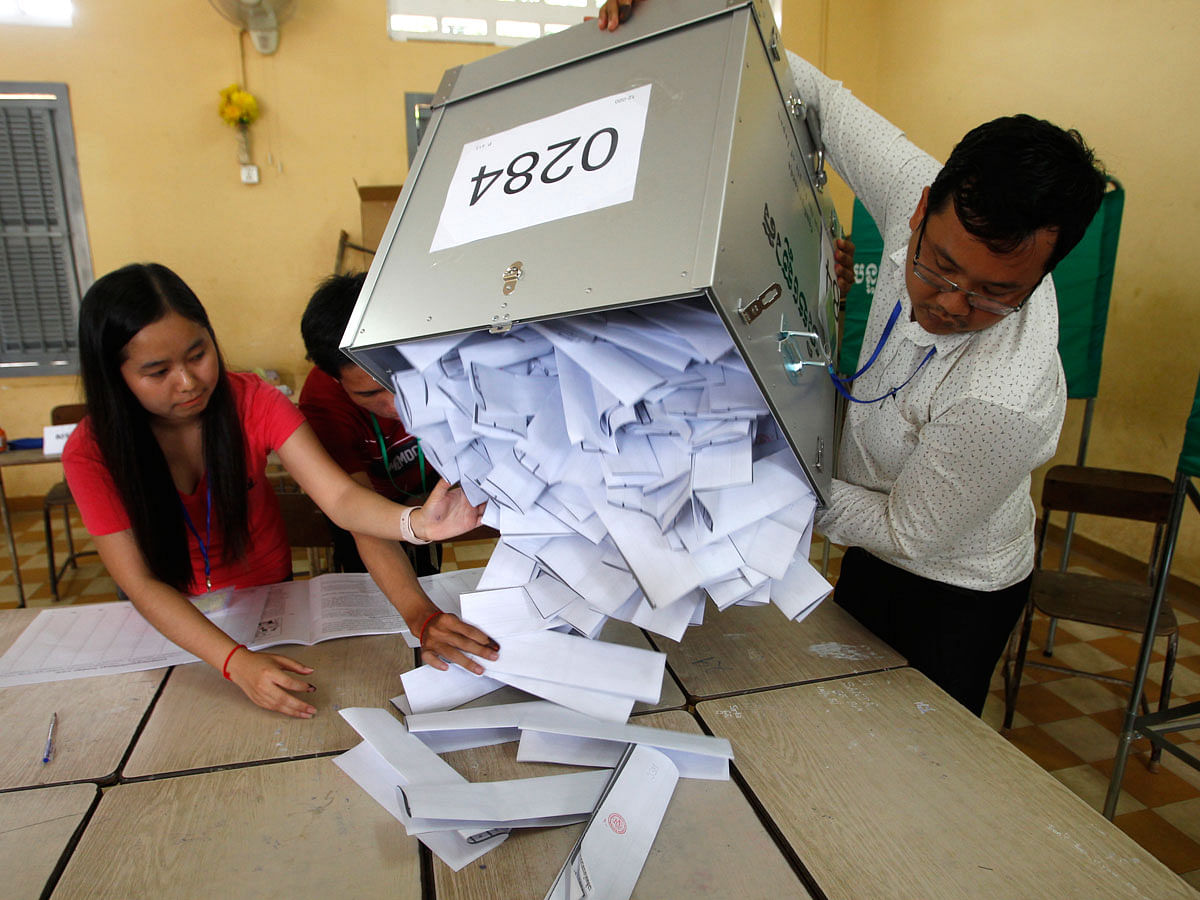 Polling station officials empty ballots boxes before counting at a polling station in Phnom Penh, Cambodia, Sunday, 29 July 2018. With the main opposition silenced, Cambodians were voting in an election Sunday virtually certain to return to office Prime Minister Hun Sen and his party who have been in power for more than three decades. Photo : AP