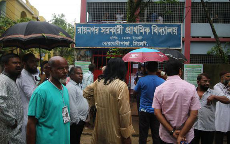 People stand in queue for casting vote in Sylhet City Corporation election at a center on Monday. Photo: UNB