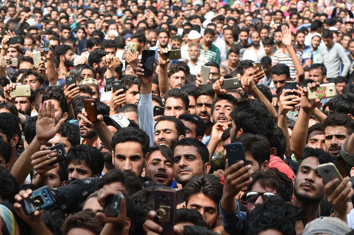 In this file photo taken on 1 August 2017, Kashmiri villagers use smartphones to take take pictures of slain rebel Arif Lelhari during his funeral at Lelhar village in Pulwama, south of Srinagar. A traditional bomb attack set off the Kashmir insurgency against Indian rule 30 years ago, but now `new age` fighters are taking the battle to new heights of bitterness that the huge military force is struggling to counter. While Kashmir remains one of the world`s most heavily militarised zones, the 500,000-plus Indian troops in Kashmir are now also fighting a social media war. -- AFP