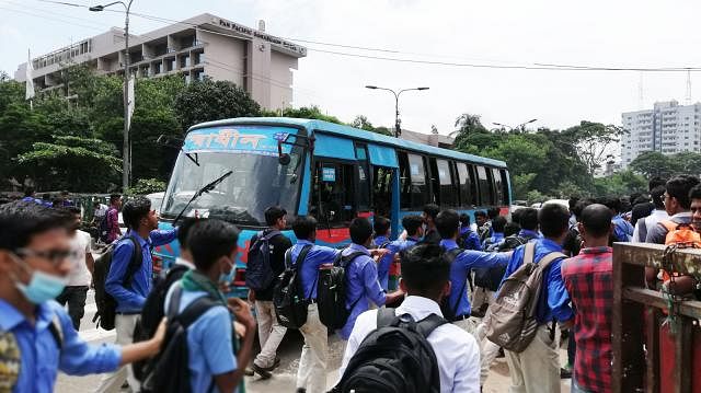 Students in uniform checking the licence of a bus driver of Swadhin Paribahan at Karwan Bazar intersection on Wednesday morning. The driver, 14, had no licence. Photo: Prothom Alo