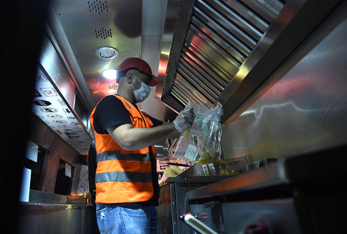 A picture taken on 5 July 2018, shows Bader al-Ajmi, 38, (C) owner of `One Way Burger` cooking food at his truck at a main street in the capital Riyadh. Over the last couple of years, this country has seen a new crop of young Saudis who grew up surrounded by oil wealth, are adapting to a new age of austerity, subsidy cuts, high inflation and fewer governmental jobs have been started private businesses that were previously considered worthy only for lowly expat workers. -- AFP