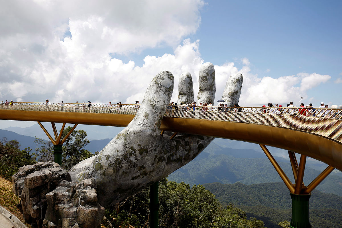 Tourists walk past giant hand structure on the Gold Bridge on Ba Na hill near Danang City, Vietnam on 1 August 2018. Photo: Reuters