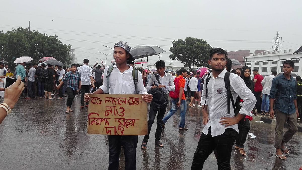 Students chant slogans, holding placards at Shantinagar intersection in Dhaka in rain on 2 August 2018. Photo: Farjana Liakat