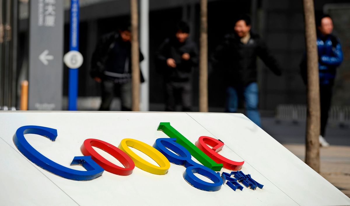This file picture taken on 21 March 2010 shows people walking near the Google company logo outside the former Google China headquarters in Beijing. After exiting China eight years ago due to censorship and hacking, Google is tuning a mobile search app that would filter blacklisted search results in order to re-enter the market, according to US media reports. Photo: AFP