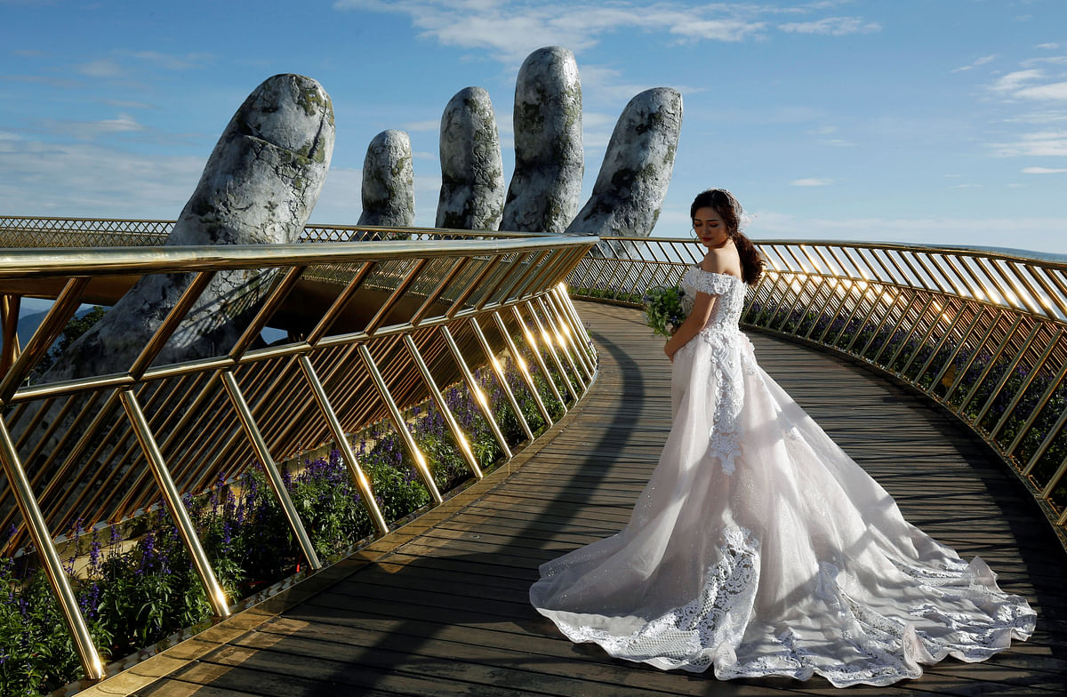 A Vietnamese bride poses for her wedding photos on Gold Bridge on Ba Na hill near Danang city, Vietnam, on 1 August 2018. Photo: Reuters