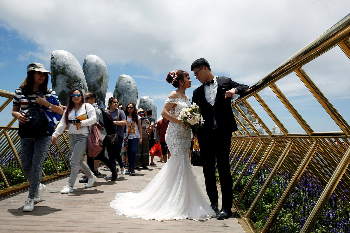 A couple pose near giant hands for their wedding photos on Gold Bridge on Ba Na hill near Danang city, Vietnam, on 1 August 2018. Photo: Reuters