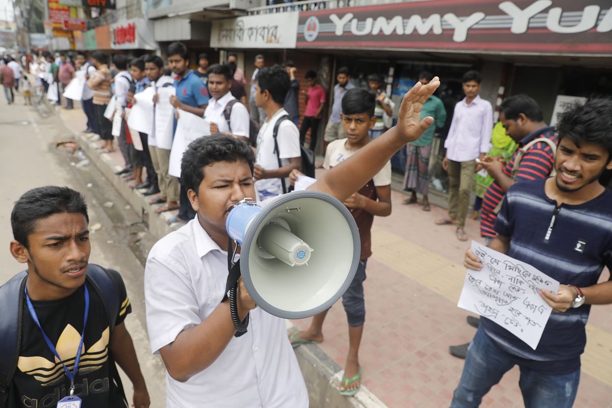 The students use amplifier asking drivers to follow traffic rules in Mohammadpur on Friday morning. Photo: Dipu Malakar