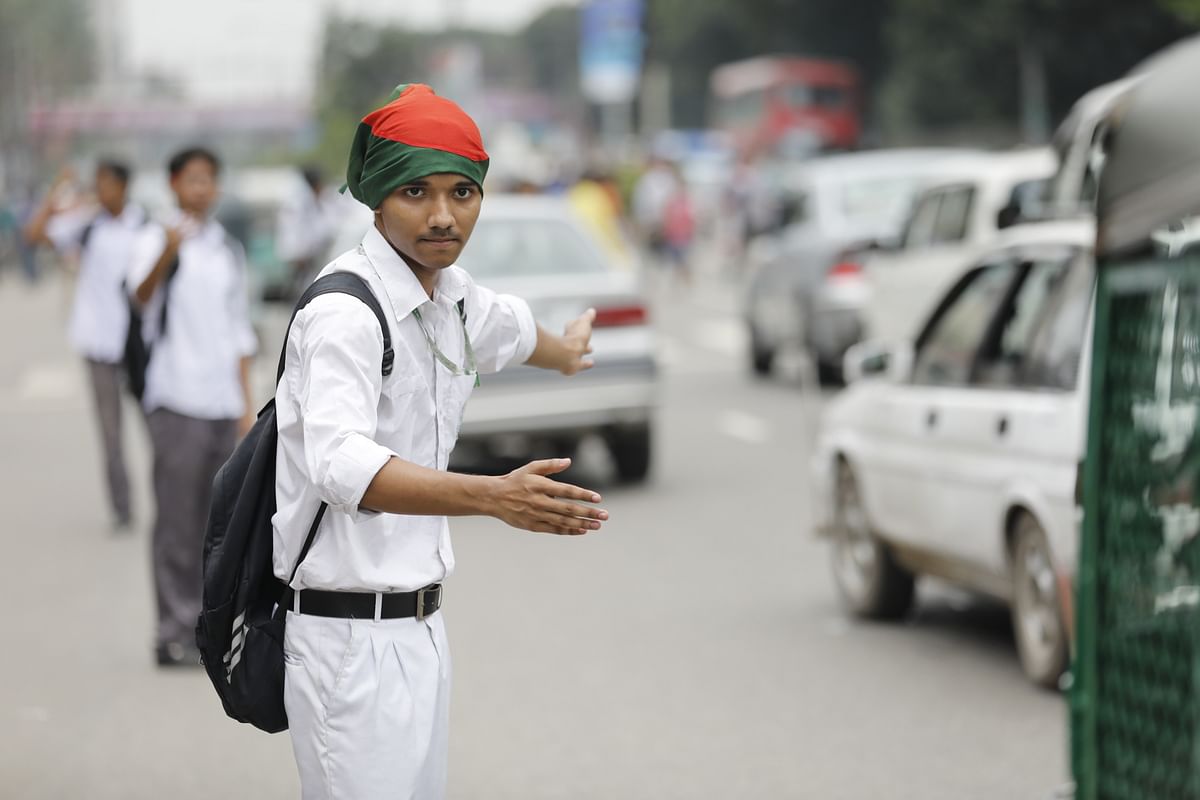 A student manages traffic in the Asad Gate area of Mohammadpur in Dhaka on 3 August. The students, mainly teenagers, took to the streets of Dhaka for the sixth consecutive day on Friday morning, demanding justice for death of their two fellow students in a road accident on 29 July. Photo: Dipu Malakar