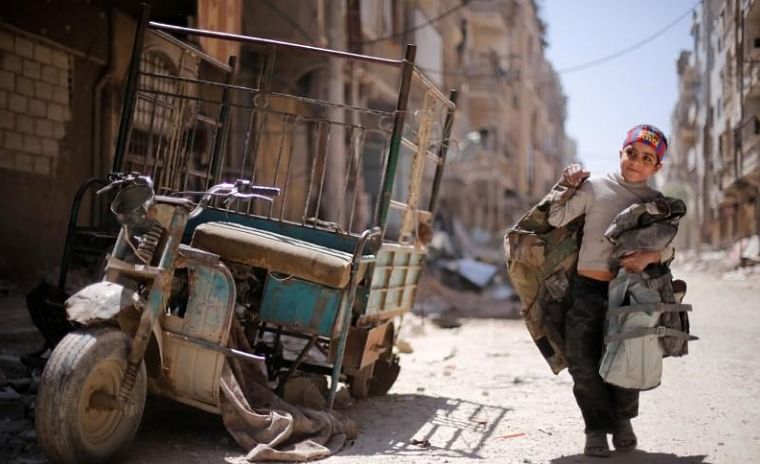 A boy walks along a damaged street at the city of Douma in Damascus, Syria on 16 April. Photo: Reuters