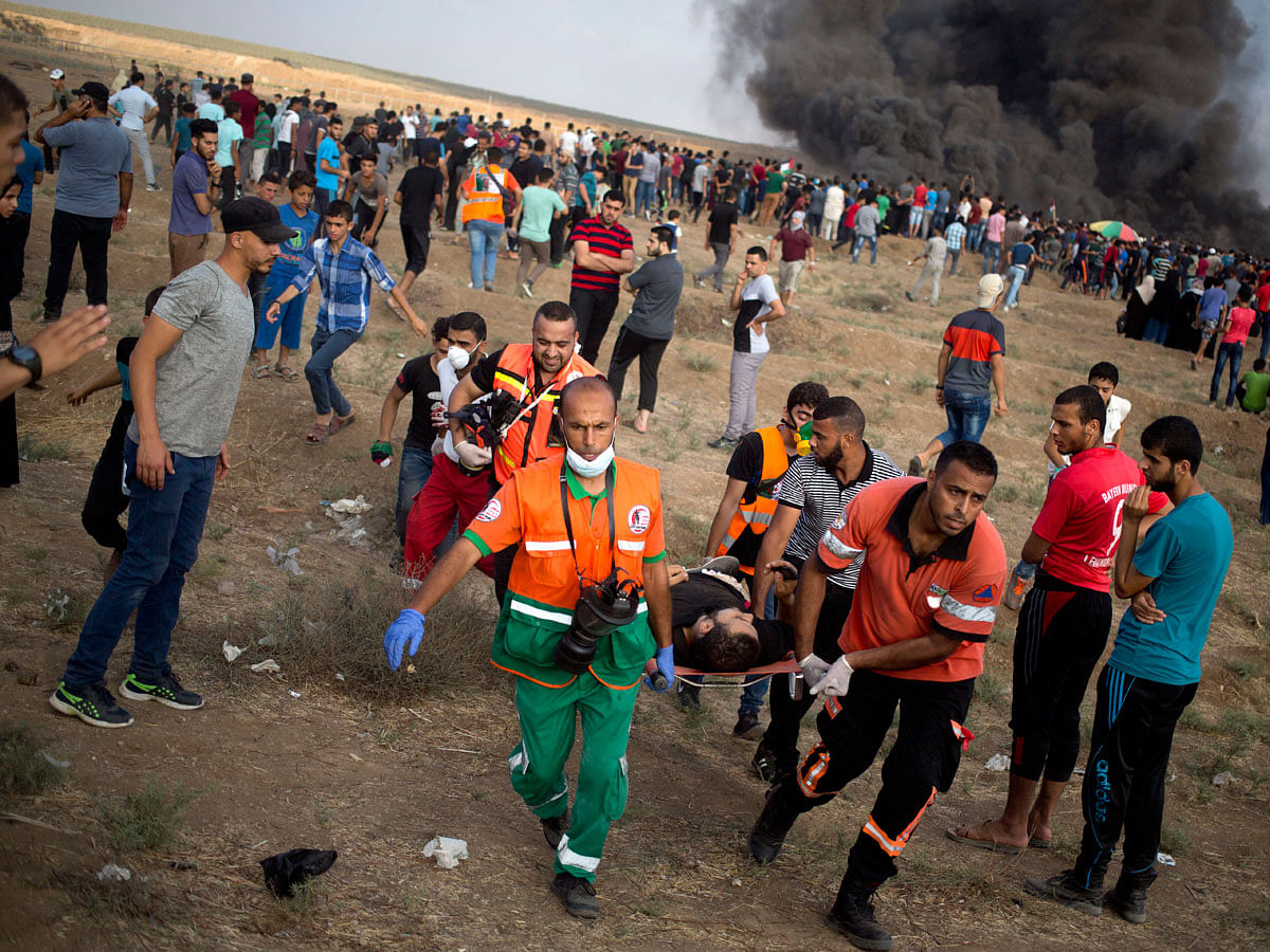 Palestinian medics evacuate a wounded man during a protest at the Gaza Strip`s border with Israel on 3 August. Photo: AP