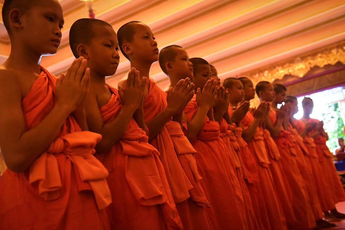 11 members of the `Wild Boars` football team pray during a ceremony to mark the end of their retreat as novice Buddhist monks at the Wat Phra That Doi Tung temple in the Mae Sai district of Chiang Rai province on 4 August 2018. Photo: AFP