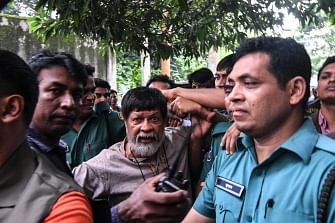 Activists and photographer Shahidul Alam arrives surrounded by policemen for an appearance in a court, in Dhaka on 6 August 2018. Photo: AFP