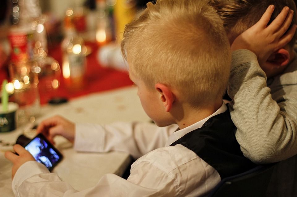 Two children look at a smartphone. Photo: pixabay.com