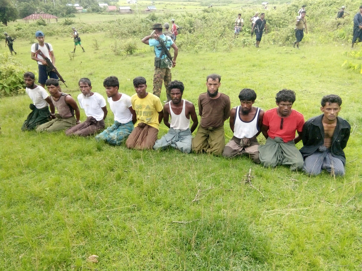 en Rohingya Muslim men with their hands bound kneel as members of the Myanmar security forces stand guard in Inn Din village. Reuters