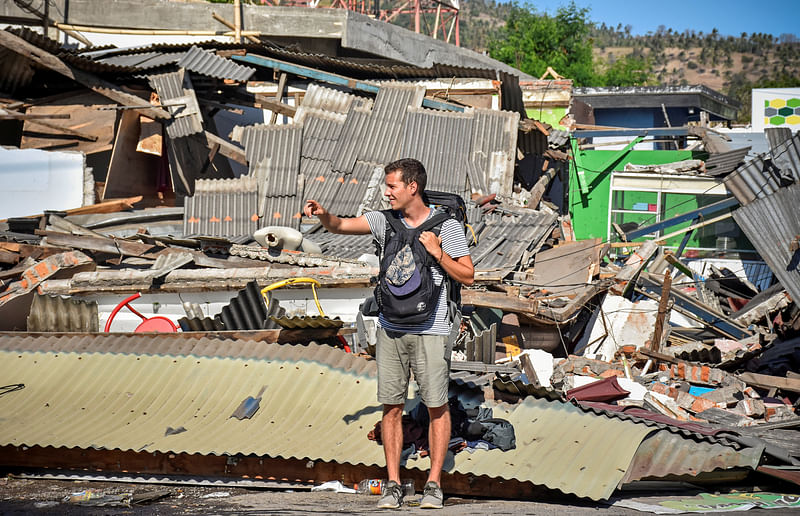 A foreign tourists stands near damaged buildings as he tries to flag down a car following a strong earthquake in Pemenang, North Lombok, Indonesia on 6 August 2018. Photo: Reuters