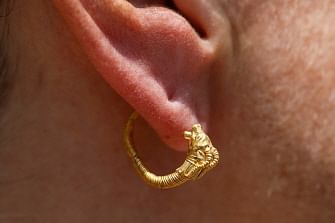 Professor Cayetana Johnson wears a rare golden earring believed to be more than 2,000 years-old, discovered at the archeological site of the City of David in East Jerusalem near the walls of the old city on 8 August 2018. Photo: AFP
