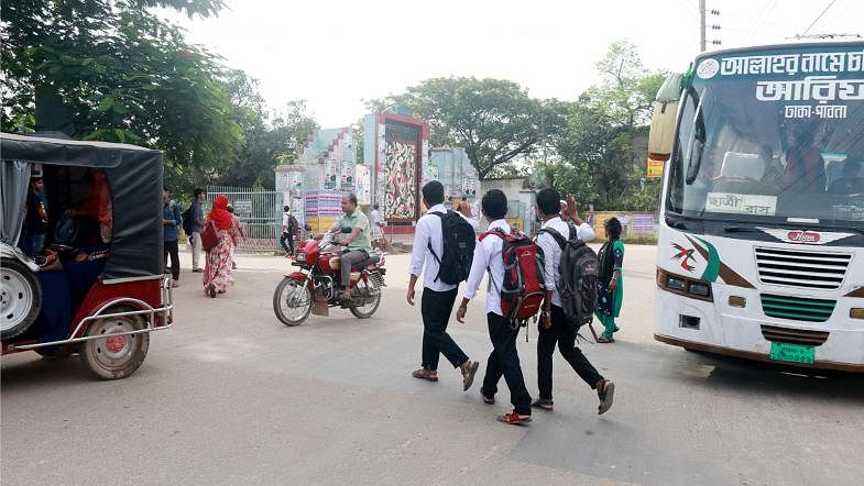 Students crossing road at Government Edward College Gate area in Pabna on 8 August. There are no zebra-crossings or speedbreakers at most of the educational institutions in Pabna. The students have to take risk while speedy buses are on the road. Photo: Hasan Mahmud