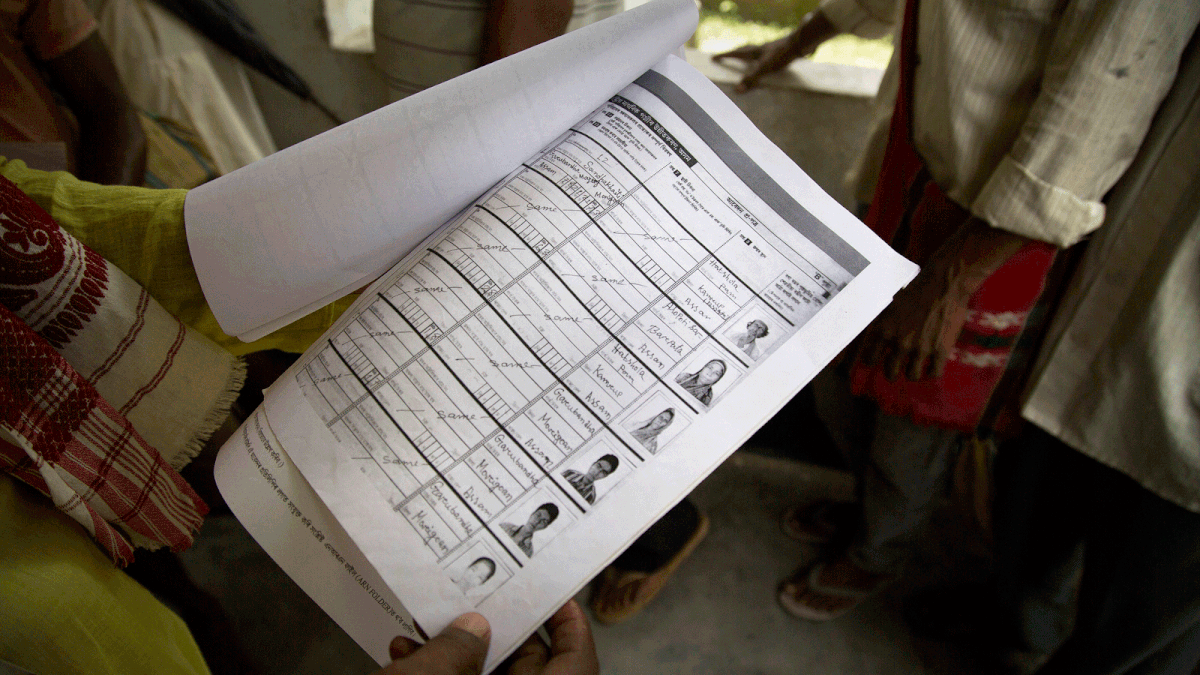 A man whose name was left out in the National Register of Citizens (NRC) draft, looks at the form he had earlier filled as he stands to receive forms to file an appeal in Mayong, 45 kilometers (28 miles) east of Gauhati, India, Friday, 10  August 2018. A draft list of citizens in Assam, released in July, put nearly 4 million people on edge to prove their Indian nationality. Nativist anger churns through Assam, just across the border from Bangladesh, with many believing the state is overrun with illegal migrants. Photo : AP