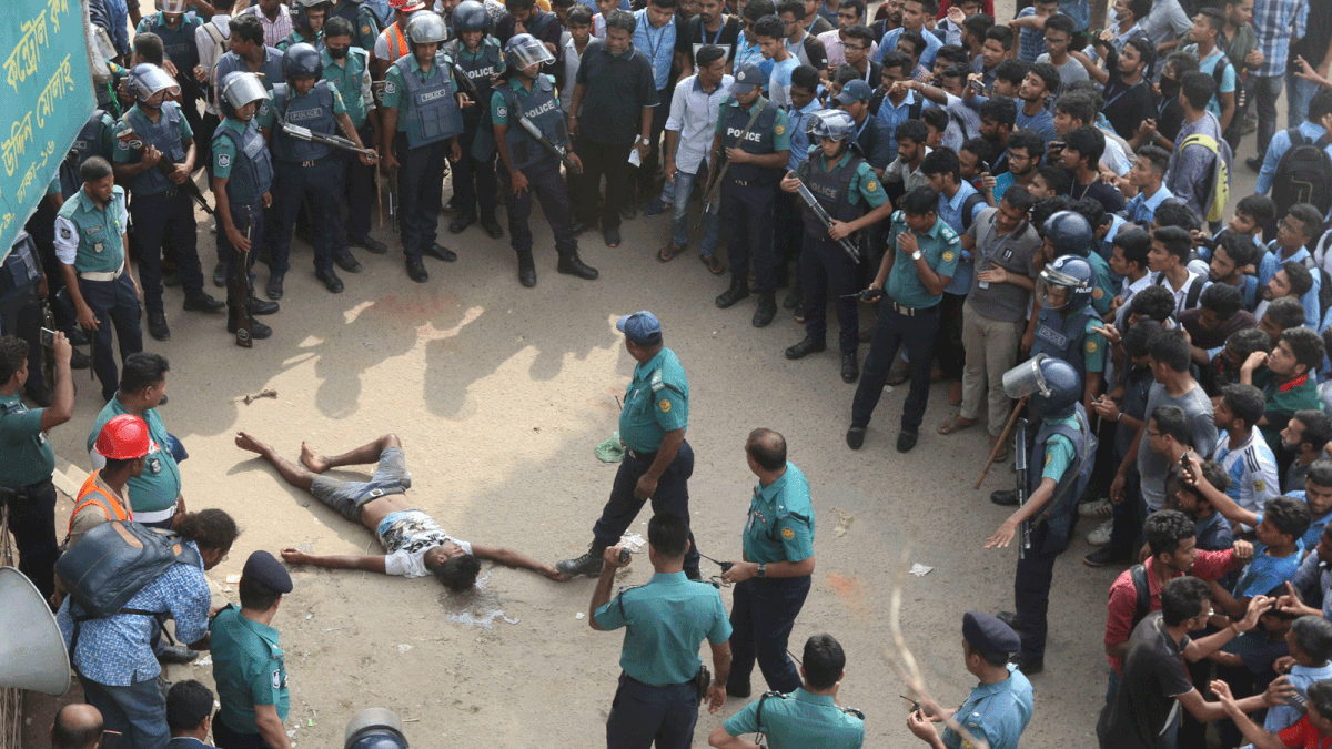 Demonstrating students recently beat a boy suspecting him bearing a bomb at Mirpur-10 roundabout in Dhaka. Police try to save him from the mob. Photo: Ashraful Alam