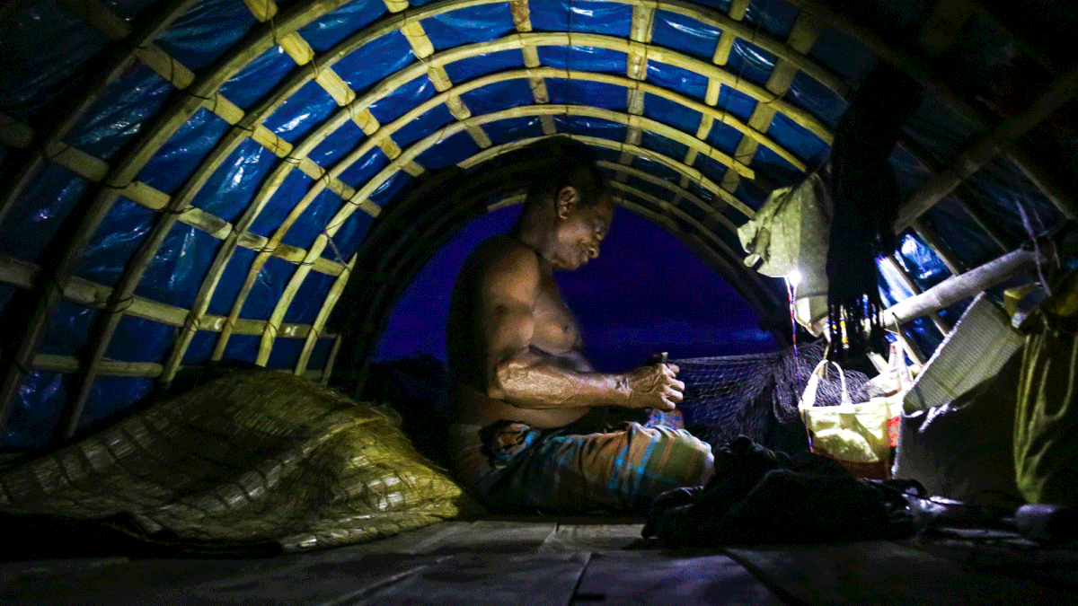 A fisherman weaves net sitting inside his boat underneath a solar lamp. He will go for fishing at night. Saddam Hossain took the photo from Kismat Fultala area of Batiaghata upazila in Khulna on 7 August.