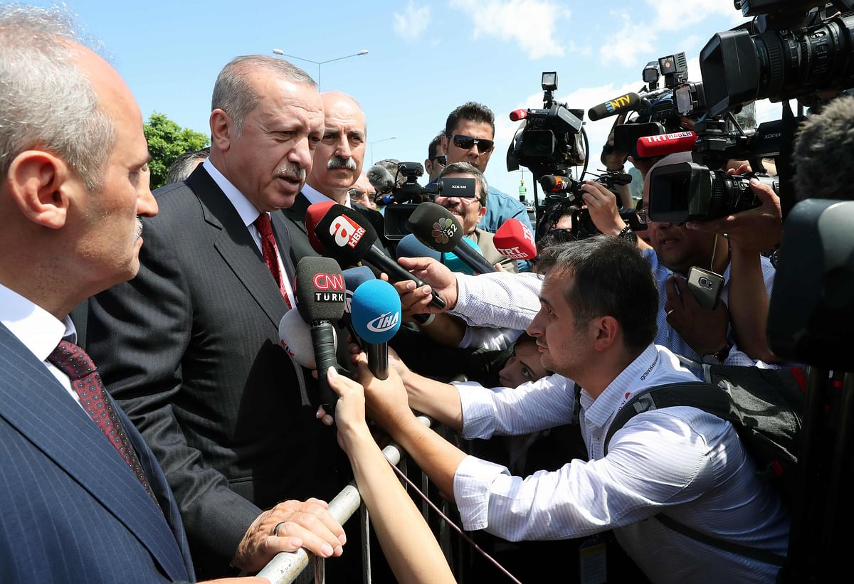 This handout picture released by the Turkish Presidential Press Service shows Turkish President Recep Tayyip Erdogan speaking to journalists during his visit to the flooded area in the Black Sea province of Ordu, on 11 August 2018. -- AFP