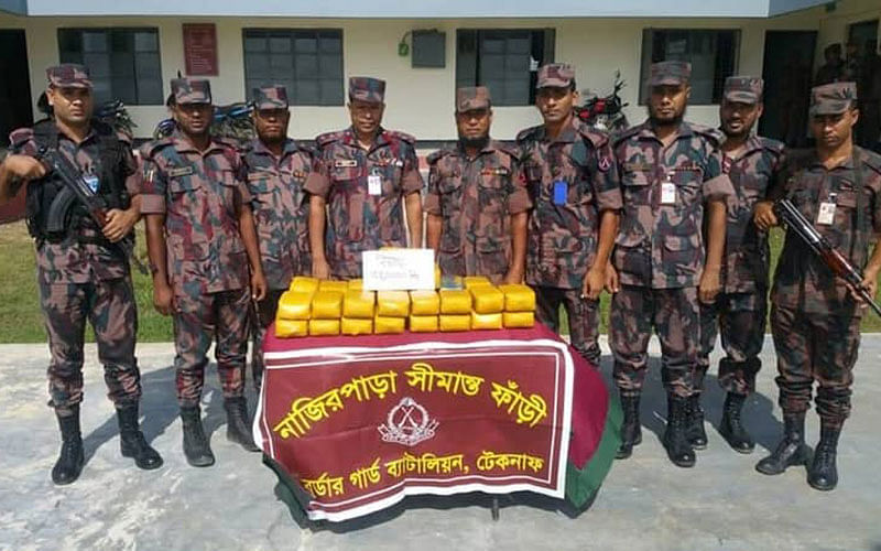Border Guard Bangladesh (BGB) members are seen with the seized packets of contraband yaba tablets in Teknaf upazila of Cox’s Bazar on 12 August 2018. Photo: UNB