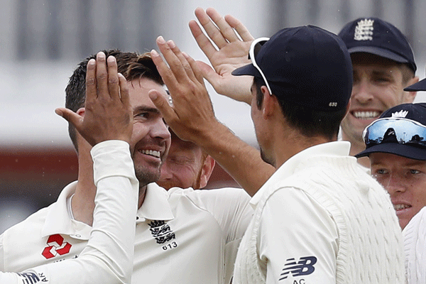 England`s James Anderson (L) celebrates with teammates after taking the wicket of India`s Lokesh Rahul during play on the fourth day of the second Test cricket match between England and India at Lord`s Cricket Ground in London on 12 August 2018. - AFP