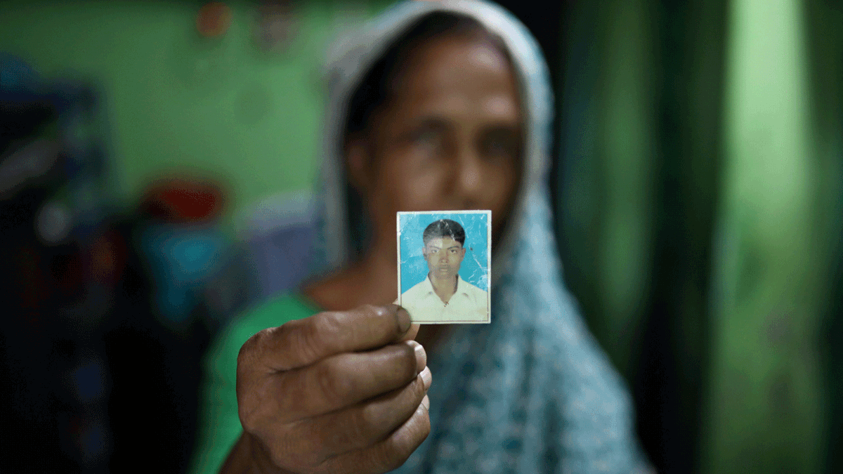 Rina Begum holds a photograph of her son Riazul Islam, alleged drug dealer who was killed by police in Tongi, Gazipur, Bangladesh, 21 July, 2018. Photo: Reuters