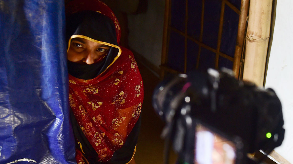 This photograph taken on 21 July 2018 shows a Rohingya refugee talking to a volunteer on camera at Balukhali camp in Ukhia, to give an account of alleged abuses by Myanmar soldiers before she fled to Bangladesh. Different teams of investigators in the world`s biggest refugee camp in Bangladesh, home to a million people, have been quietly documenting what Myanmar`s Muslim minority suffered in 2017. AFP