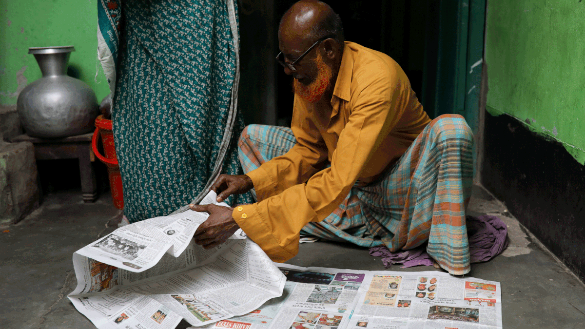 Hafiz Mia flips through the newspapers, for news of his son Riazul Islam, an alleged drug dealer who was killed by police in Tongi, Gazipur, Bangladesh, 21 July, 2018. Photo: Reuters