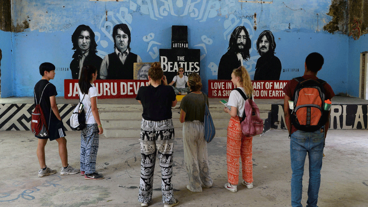 This picture taken on 18 June, 2018 shows tourists taking pictures of a mural at the now-derelict ashram visited by the Beatles 50 years ago, in Rishikesh in northern India. Photo: AFP